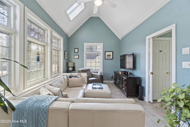 living room featuring ornamental molding, high vaulted ceiling, ceiling fan, and a skylight