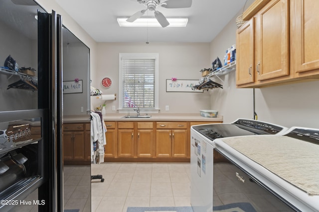 laundry area with sink, cabinets, light tile patterned floors, ceiling fan, and independent washer and dryer