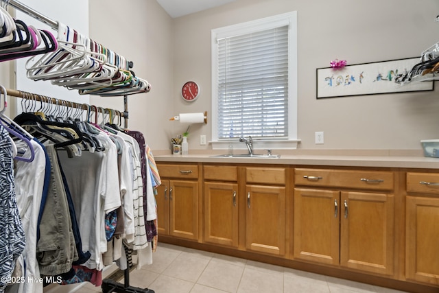 spacious closet with sink and light tile patterned flooring