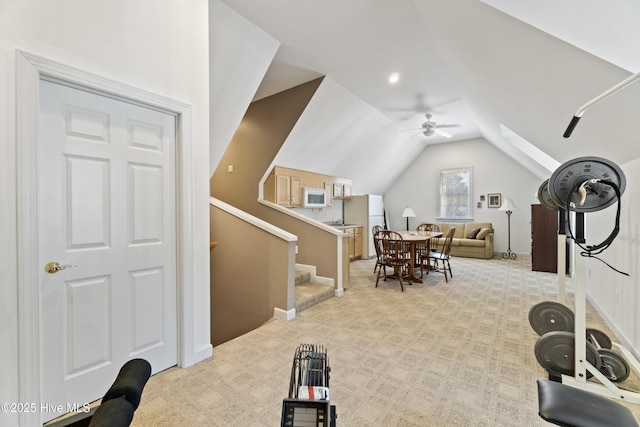 workout area featuring ceiling fan, vaulted ceiling, and light carpet