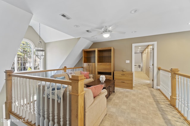 carpeted living room with ceiling fan with notable chandelier and vaulted ceiling