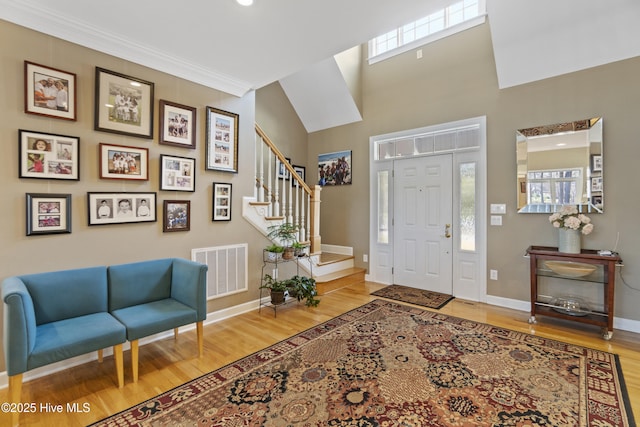 entrance foyer with wood-type flooring and ornamental molding