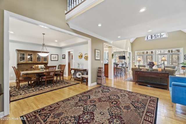 living room with light hardwood / wood-style flooring, high vaulted ceiling, and a raised ceiling