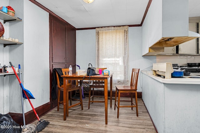 dining area featuring ornamental molding and light hardwood / wood-style floors