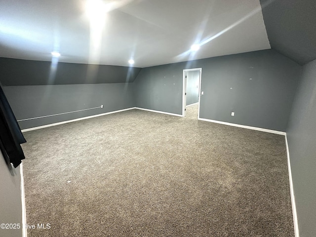 additional living space with carpet floors and vaulted ceiling