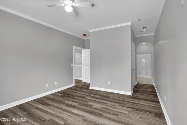 unfurnished room with crown molding, dark hardwood / wood-style floors, and ceiling fan