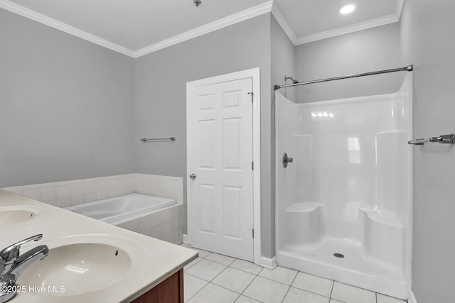 bathroom with ornamental molding, tile patterned floors, vanity, and tiled tub