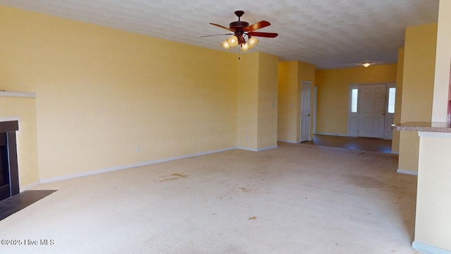 unfurnished living room with ceiling fan and a textured ceiling