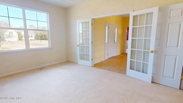 empty room with french doors and light colored carpet