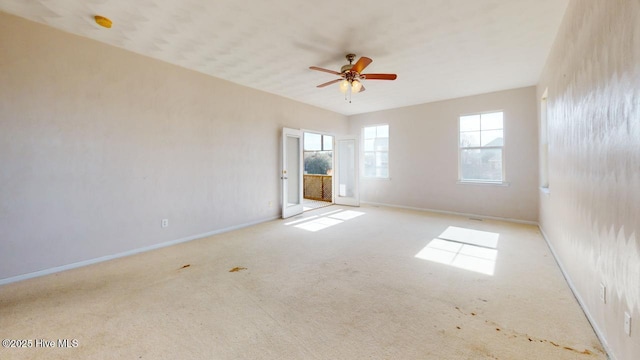 carpeted spare room featuring ceiling fan