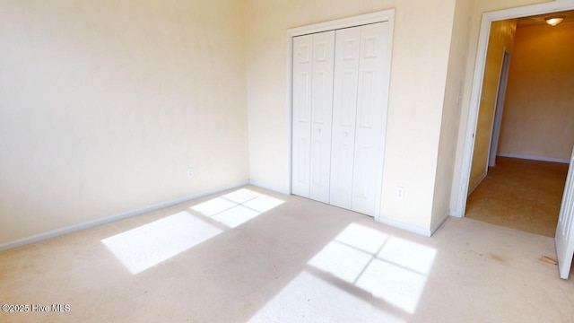 unfurnished bedroom featuring a closet and light carpet