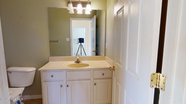 bathroom with vanity, a notable chandelier, and toilet