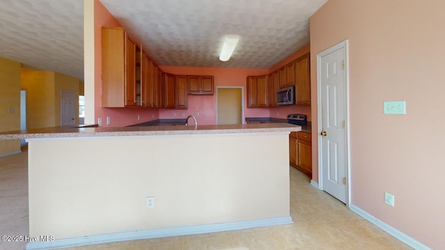 kitchen featuring sink, kitchen peninsula, and a textured ceiling