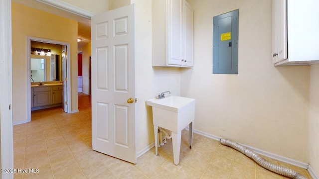 washroom featuring cabinets, electric panel, and sink