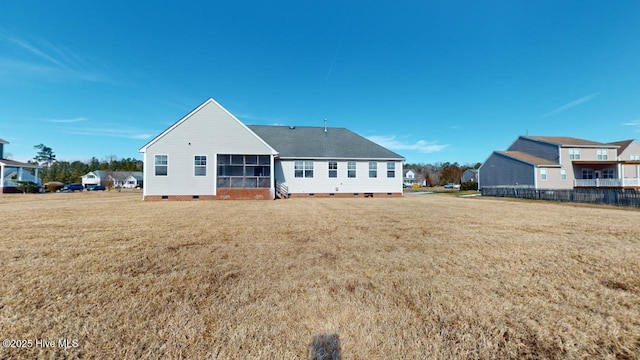 rear view of property featuring a sunroom and a yard