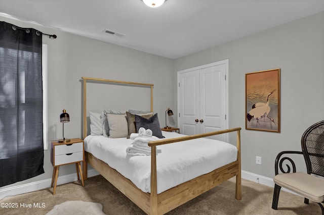 bedroom featuring light colored carpet and a closet