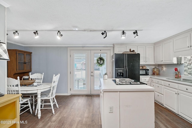 kitchen with black appliances, dark wood finished floors, a sink, and french doors