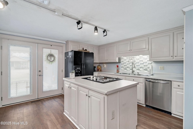 kitchen featuring a center island, dark wood finished floors, light countertops, a sink, and black appliances