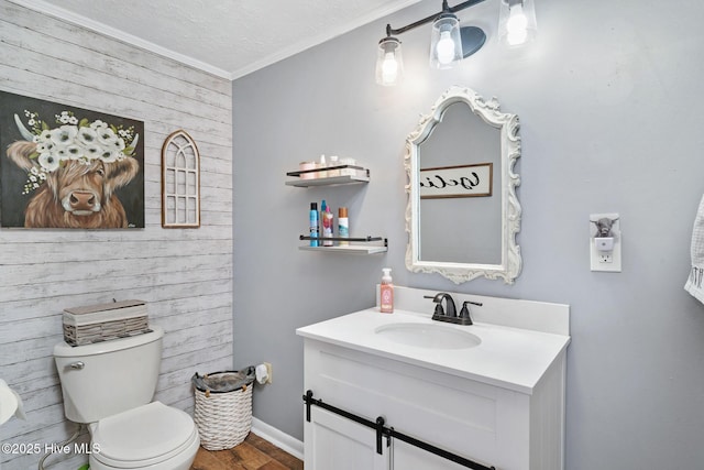 bathroom with toilet, wood finished floors, a textured ceiling, vanity, and wood walls