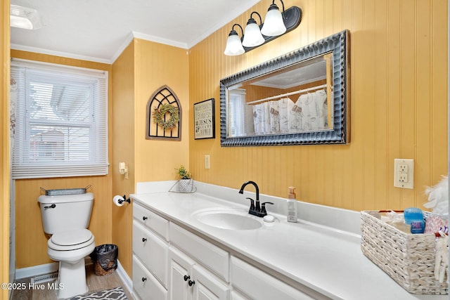 bathroom with toilet, ornamental molding, vanity, baseboards, and wallpapered walls