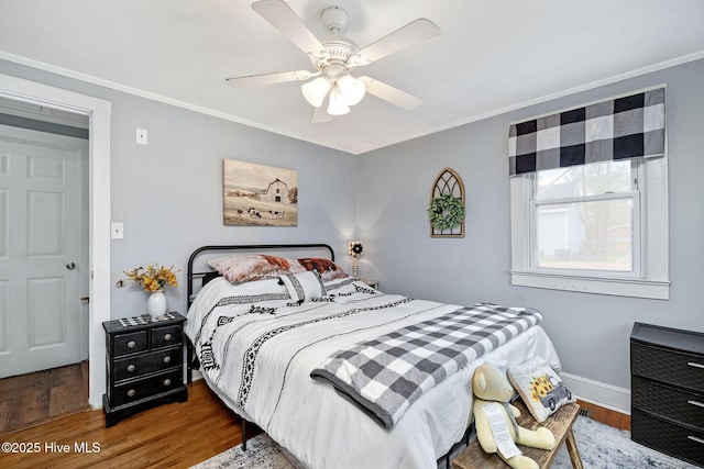 bedroom with ornamental molding, ceiling fan, baseboards, and wood finished floors