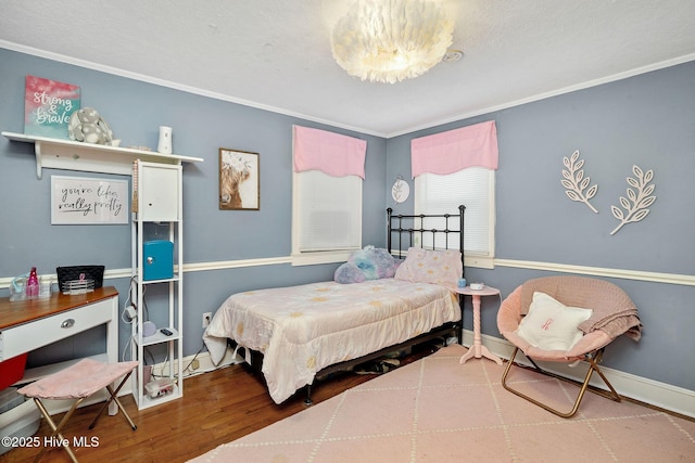 bedroom featuring ornamental molding, wood finished floors, and baseboards