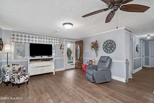 living room featuring baseboards, ceiling fan, ornamental molding, wood finished floors, and a textured ceiling