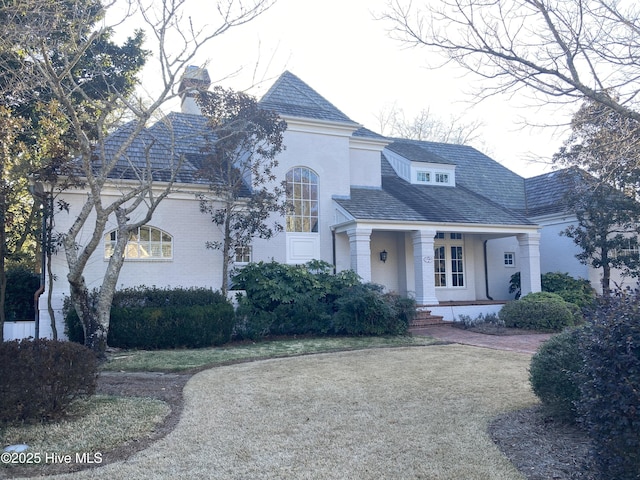 view of front facade featuring covered porch and a front lawn