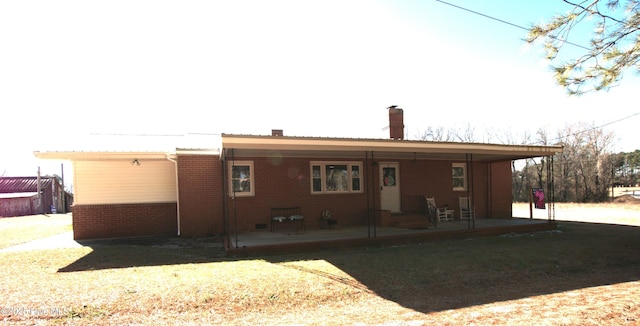 back of property featuring a lawn and a patio