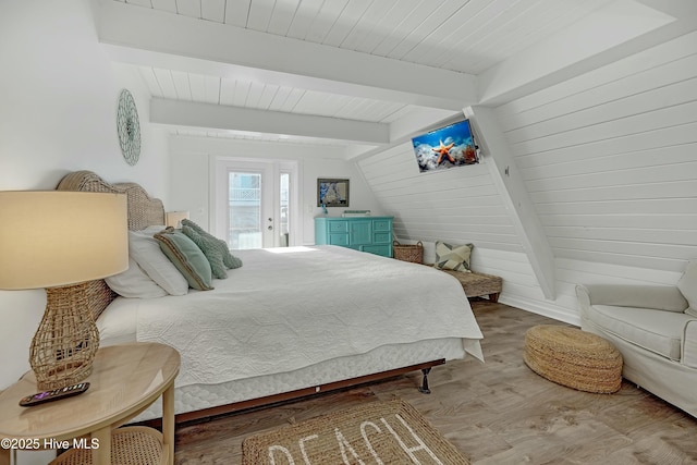 bedroom featuring lofted ceiling with beams, wooden ceiling, and wood finished floors