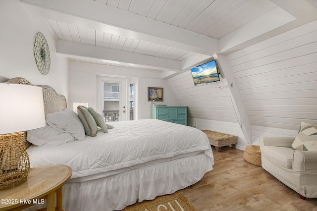 bedroom with wooden walls, wooden ceiling, wood finished floors, access to outside, and beam ceiling