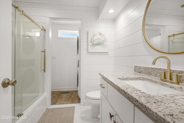 bathroom with bath / shower combo with glass door, recessed lighting, visible vents, toilet, and vanity