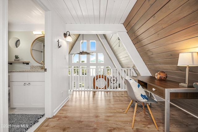 office space with lofted ceiling with beams, light wood-type flooring, and wooden ceiling