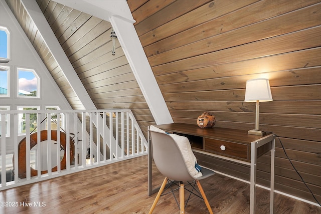 office featuring lofted ceiling with beams, wooden ceiling, wood finished floors, and wooden walls