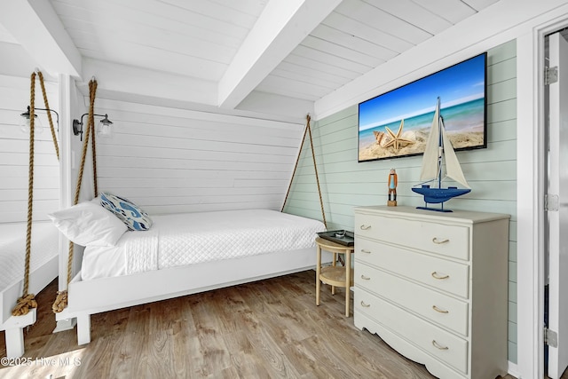 bedroom featuring wooden ceiling, light wood-style flooring, wooden walls, and beamed ceiling