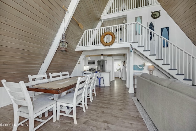 dining area with high vaulted ceiling, stairway, wood finished floors, and wood ceiling