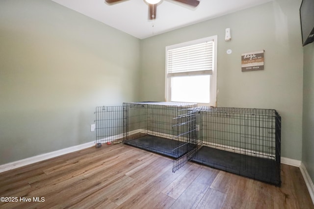 interior space with ceiling fan, baseboards, and wood finished floors