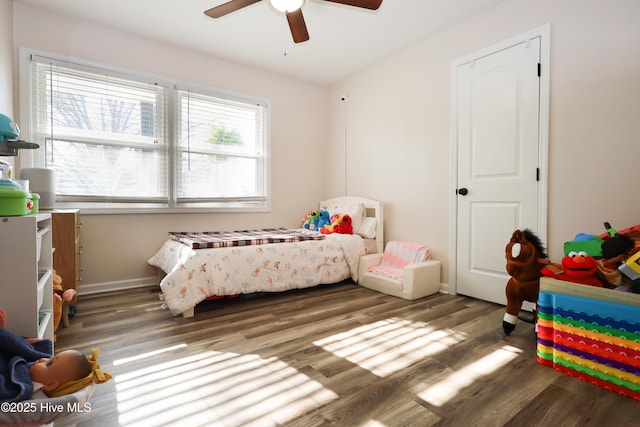 bedroom with ceiling fan, baseboards, and dark wood-style flooring