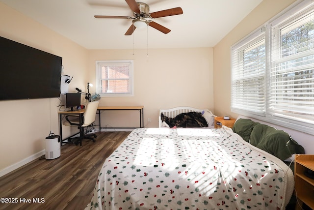 bedroom with ceiling fan, multiple windows, baseboards, and dark wood finished floors