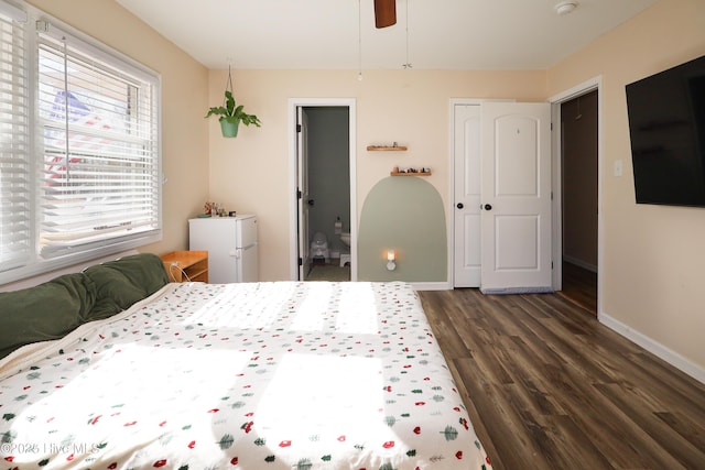 bedroom with dark wood-type flooring, a closet, ceiling fan, and baseboards