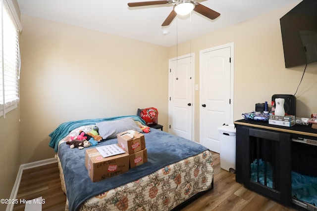 bedroom featuring dark wood-style flooring, ceiling fan, and baseboards