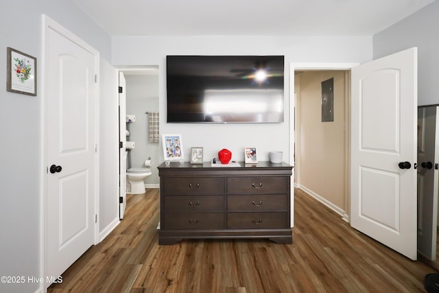 bedroom with dark wood finished floors, electric panel, and baseboards