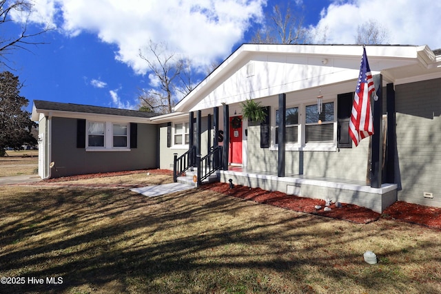 view of front of property with entry steps, a front lawn, and brick siding