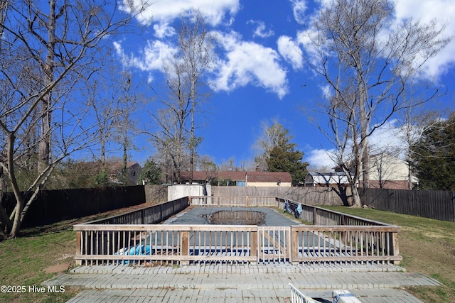 view of yard with a covered pool, a fenced backyard, and a wooden deck