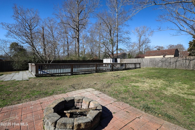 view of yard with a patio area, a fire pit, a swimming pool, and a fenced backyard