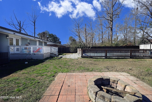 view of yard featuring a fenced backyard, a fire pit, a deck, and a patio