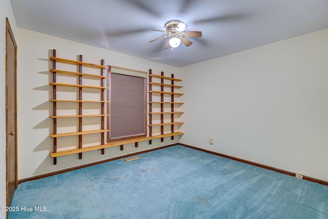 carpeted spare room featuring ceiling fan