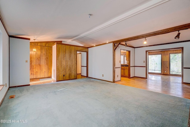 unfurnished room with lofted ceiling with beams, light carpet, and wooden walls