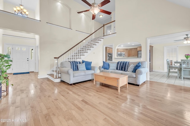 232 E Ivybridge Dr, Hubert, NC 28539 - living room with a ceiling fan, a high ceiling, stairway, light wood-style flooring, and a chandelier