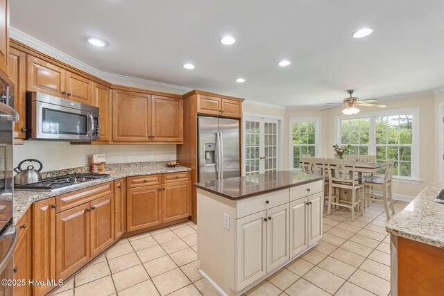 232 E Ivybridge Dr, Hubert, NC 28539 - kitchen featuring stainless steel appliances, crown molding, light tile patterned floors, ceiling fan, and light stone counters